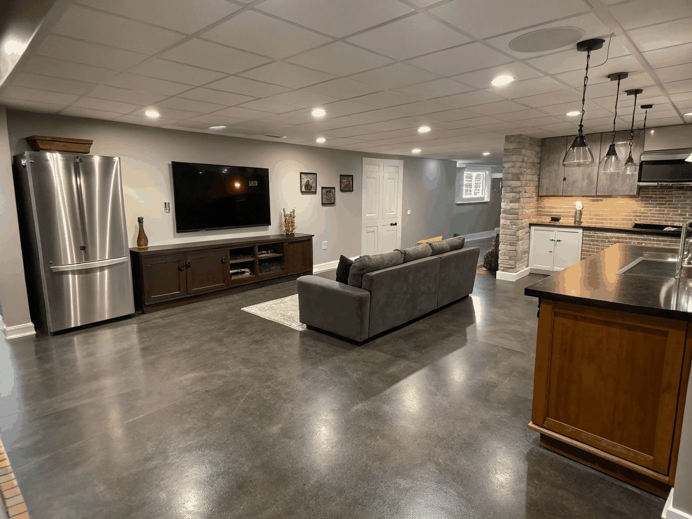 Finished daylight basement renovation in Decatur featuring custom white oak millwork wet bar and recessed lighting