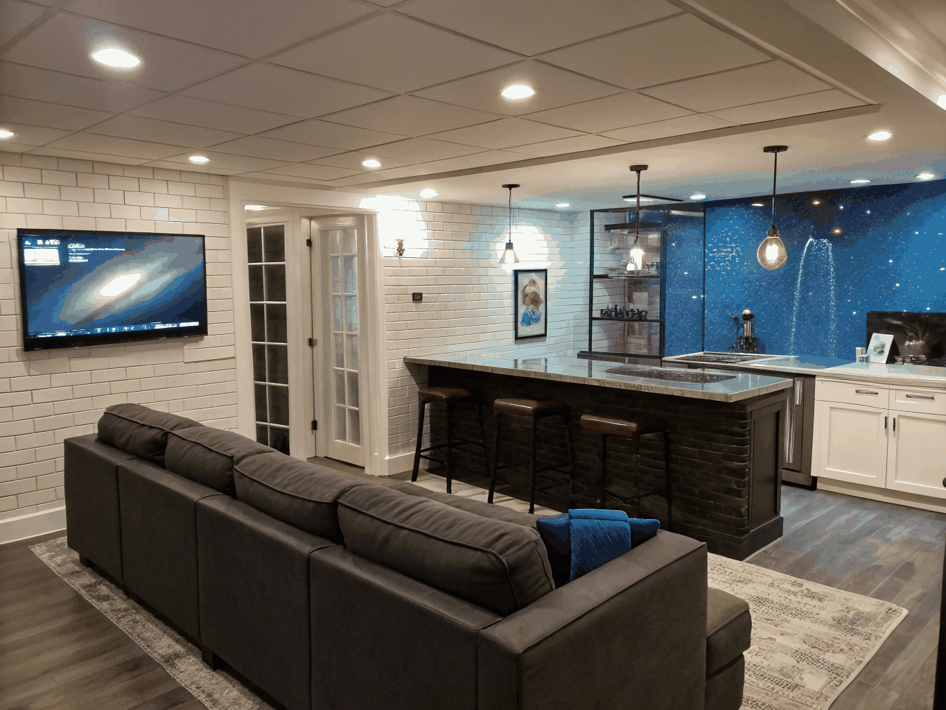Finished daylight basement entertainment room with wet bar and recessed lighting