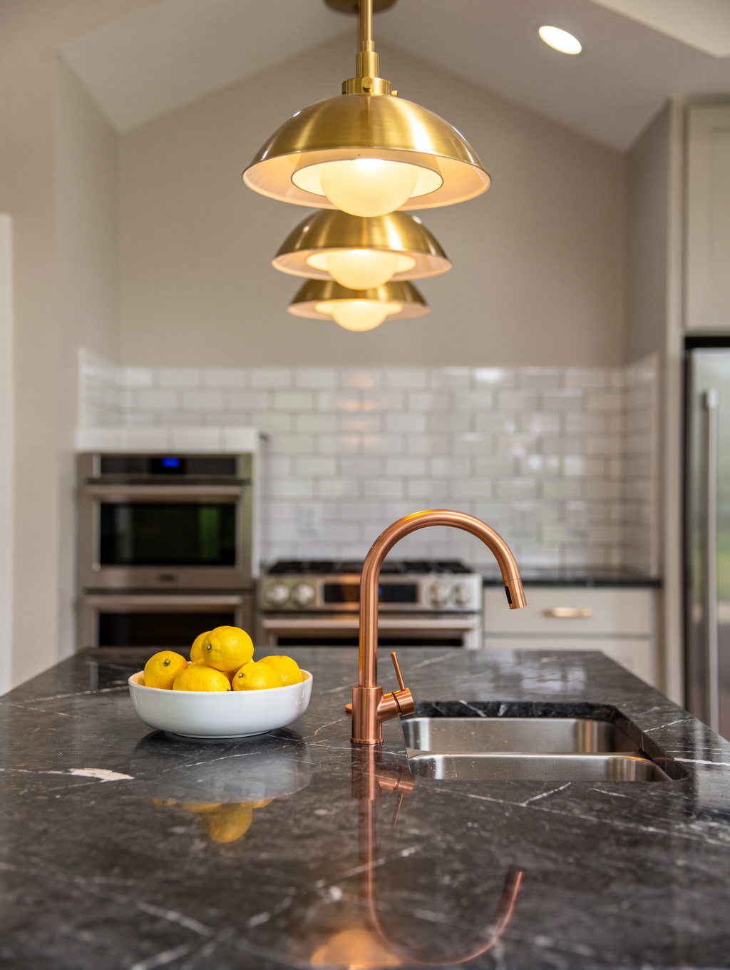 Close-up detail of architectural brass fixtures, quartz backsplash, and task lighting